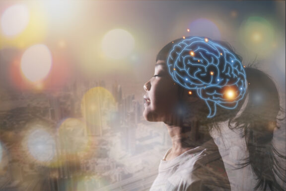Profile of a girl in side view with a glowing blue brain network overlay and a colorful cityscape backdrop.